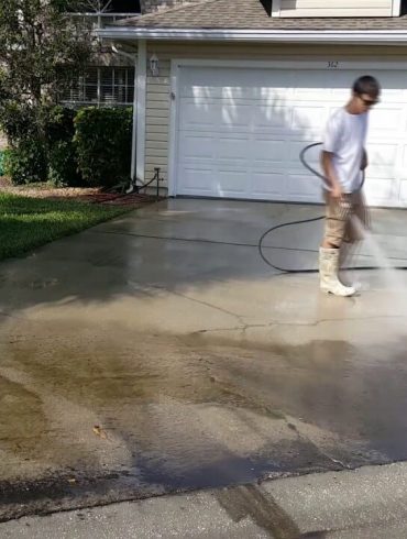 Person power washing their driveway