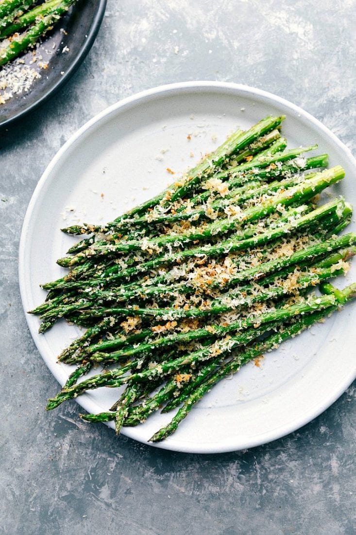Roasted asparagus topped with shredded parmesan on dinner plate