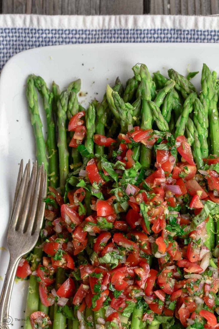Blanched asparagus topped with herbs and tomatoes