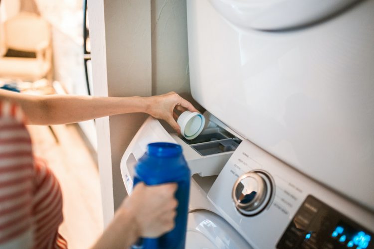 pouring laundry detergent into machine