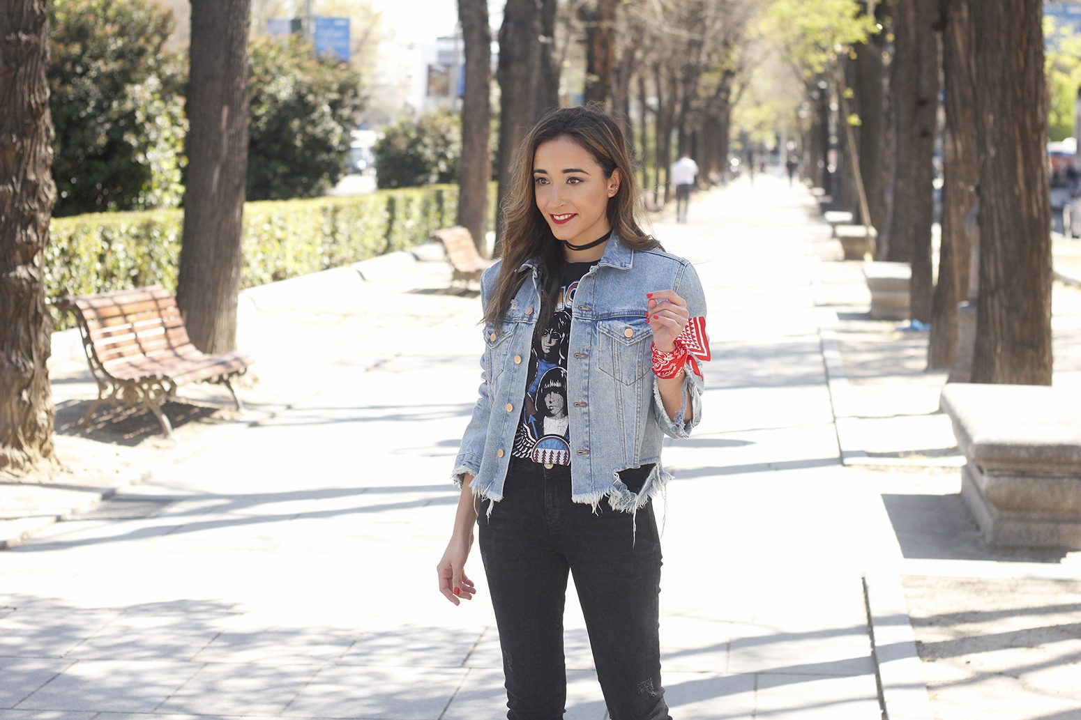 Smiling woman wearing light distressed jean jacket on sidewalk