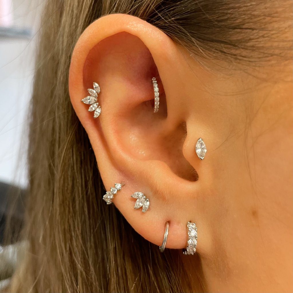 Close-up of dark-haired woman with earring stack in right ear.