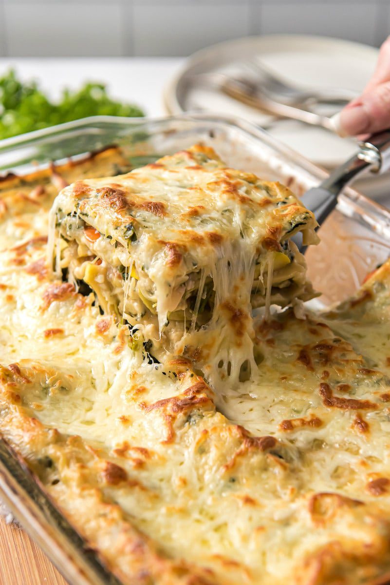 Slice of garden vegetable lasagna being removed from pan with spatula