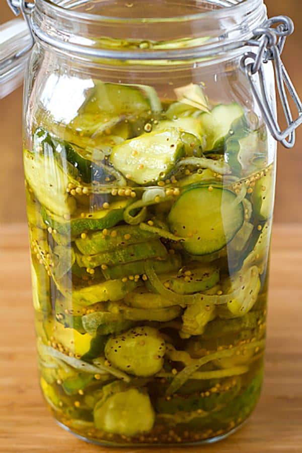 Sealed mason jar full of pickles on wooden counter