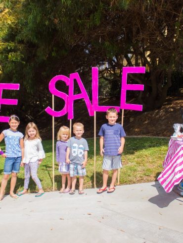 Kids standing beside table at bake sale for fundraising effort