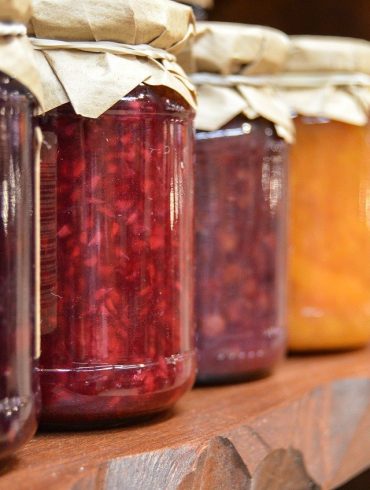 Shelf with multiple jars of homemade jam on it