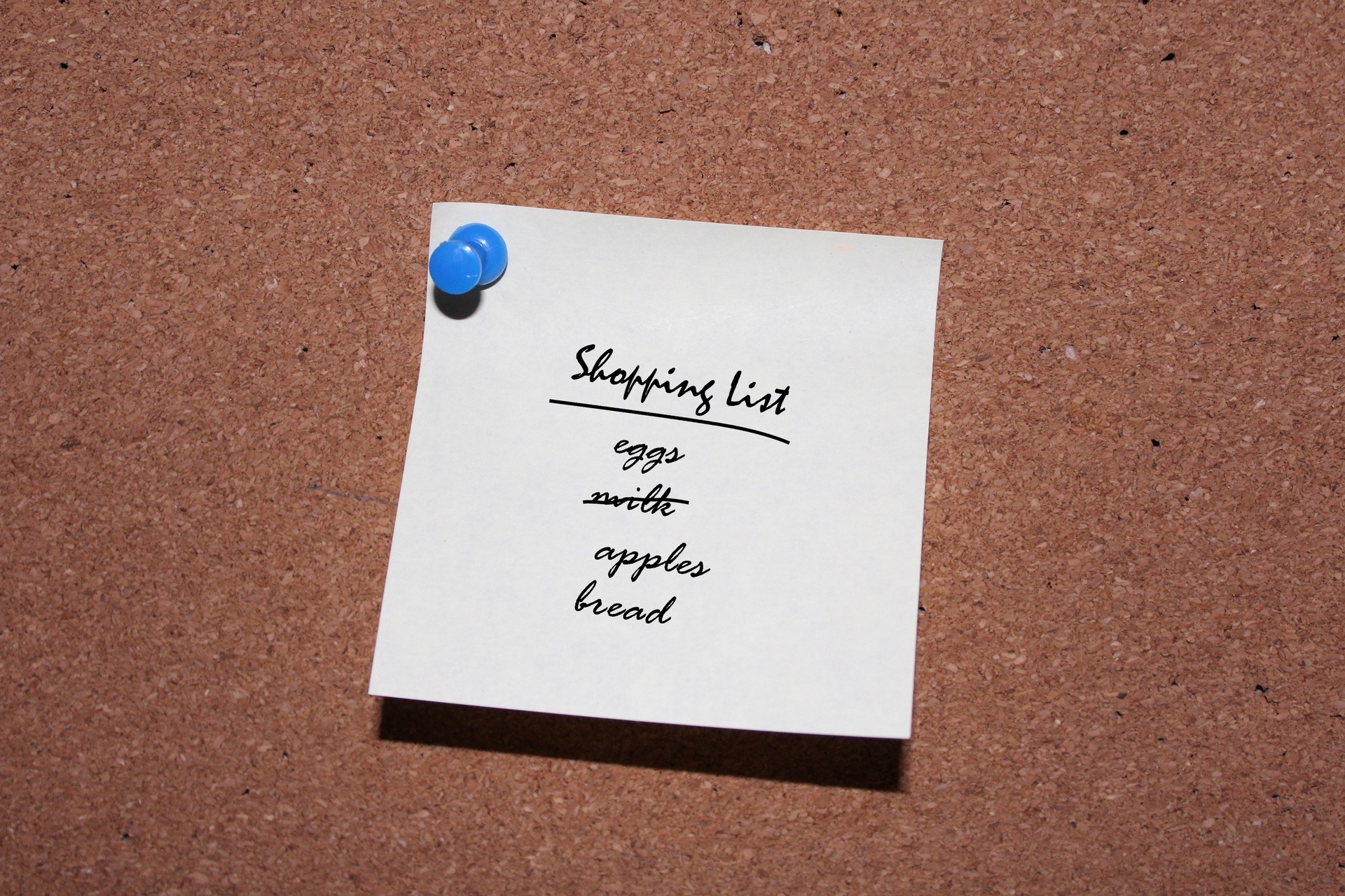Image of shopping list on note tacked to cork board