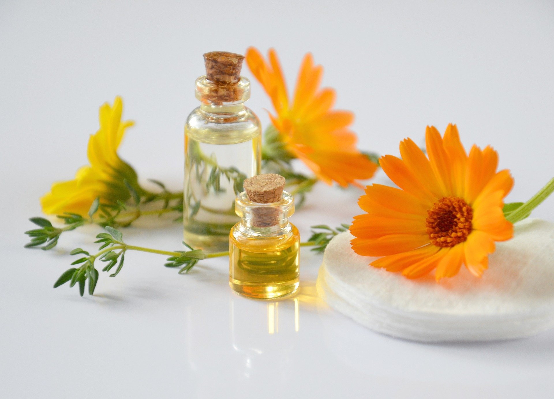 Essential oils next to orange flowers