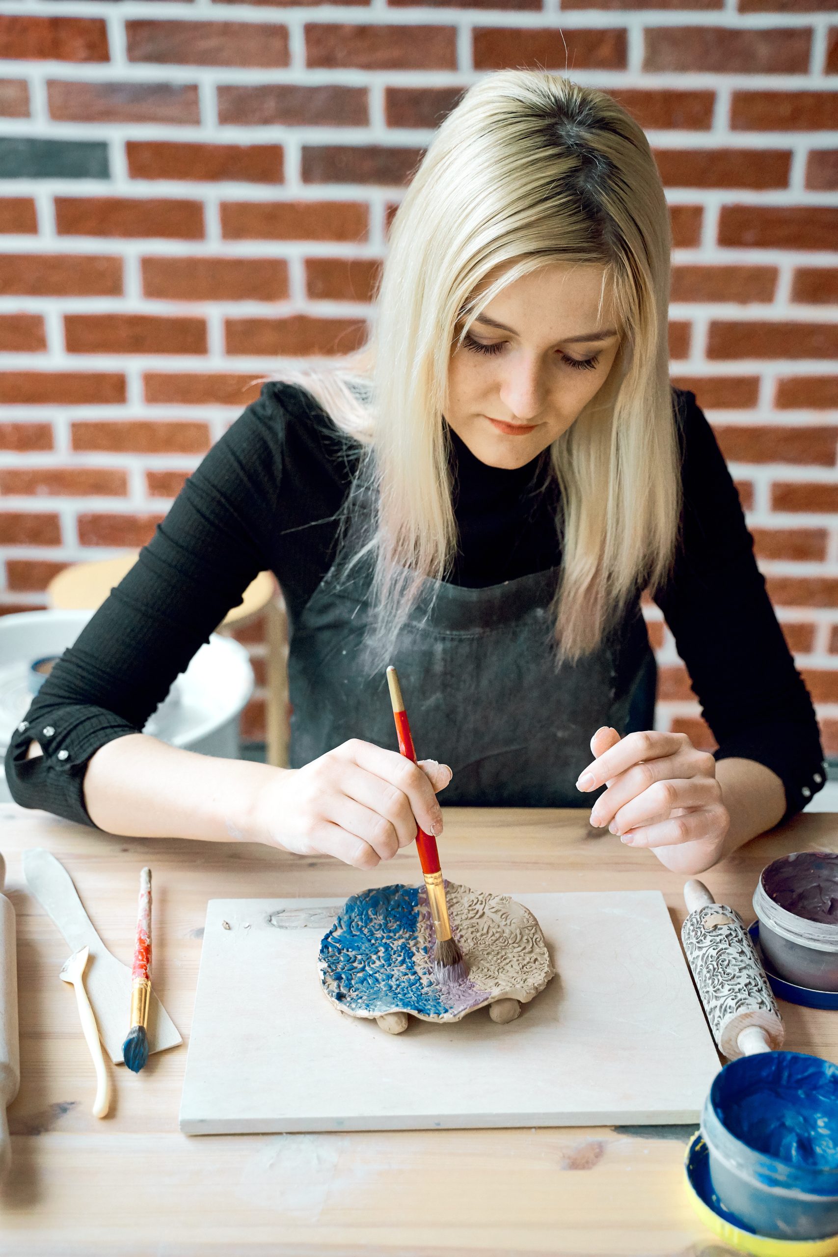Woman painting a ceramic plate