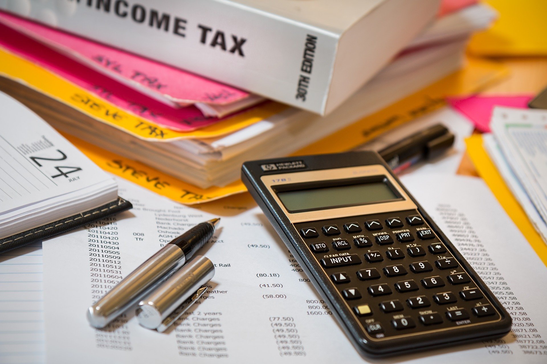 Calculator and pen on top of financial documents